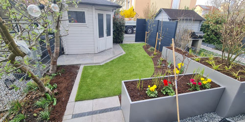 Kleingarten mit perfektem Rasen und gepflegten Beeten